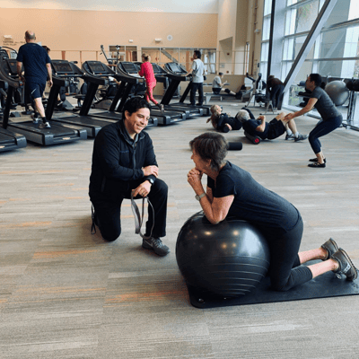 trainer and member talking inside a medical fitness center management facility